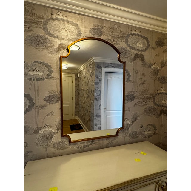 Striking wall mirror with an arched, decorative silhouette and warm gold frame. Makes a beautiful focal point over a...