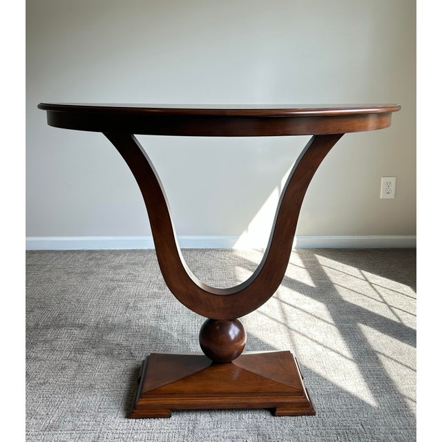 Elegant pair of J. Alexander ‘Sardinia’ console tables featuring dramatic neoclassical lyre-form bases and demi-lune tops...