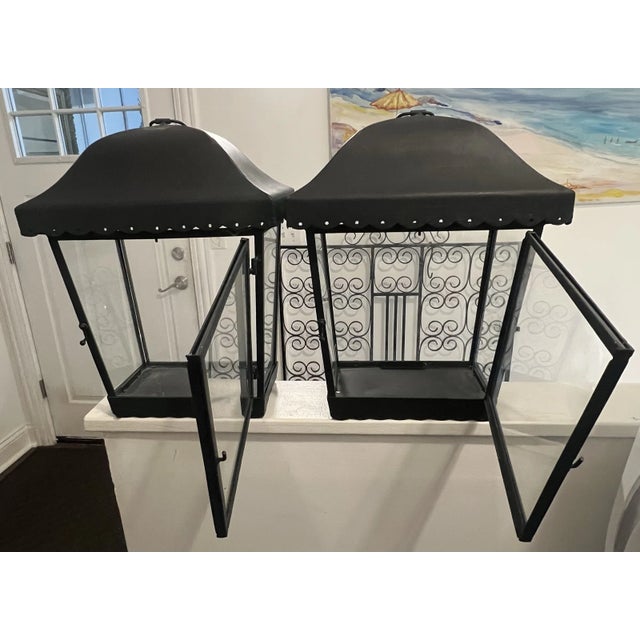 Black tole lanterns with opening front window and pierced scalloped gallery edge. The lanterns have a hanging lip attached...