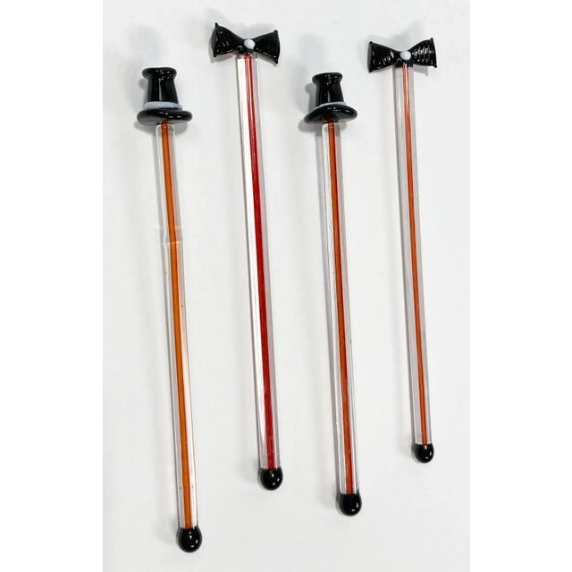 Festive set of four vintage blown glass swizzle sticks topped with black top hats and black bow ties, each with white...