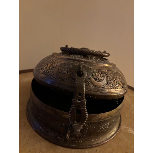 This ornate canister is a charming example of Middle Eastern artistry. It features an intricate floral pattern and a warm,...