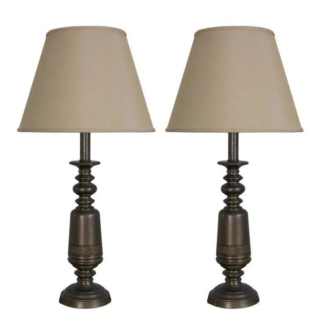 An elegant pair of American Mid-Century brass table lamps from the 1950s, distinguished by their sculptural turned forms...