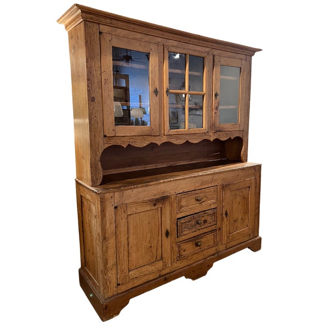 A lovely antique Irish pine bookcase cabinet or hutch. The top portion of this piece has 3 glass doors that open to reveal...