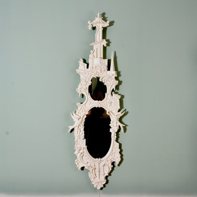 Intricately carved frame with scroll, bird and pagoda castle designs with cream tone gloss finish. Marked on reverse...