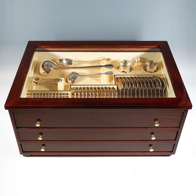 Elegant cutlery set made of solid silver for 12 people, consisting of 125 parts, in wooden display cabinet. Dating: circa...