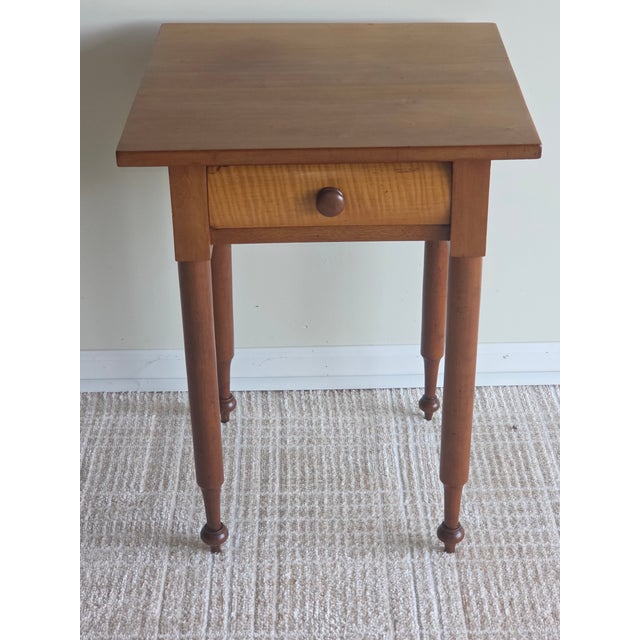 This is a 19th century single drawer federal style table. It is constructed of solid cherry and accented by a stunning...
