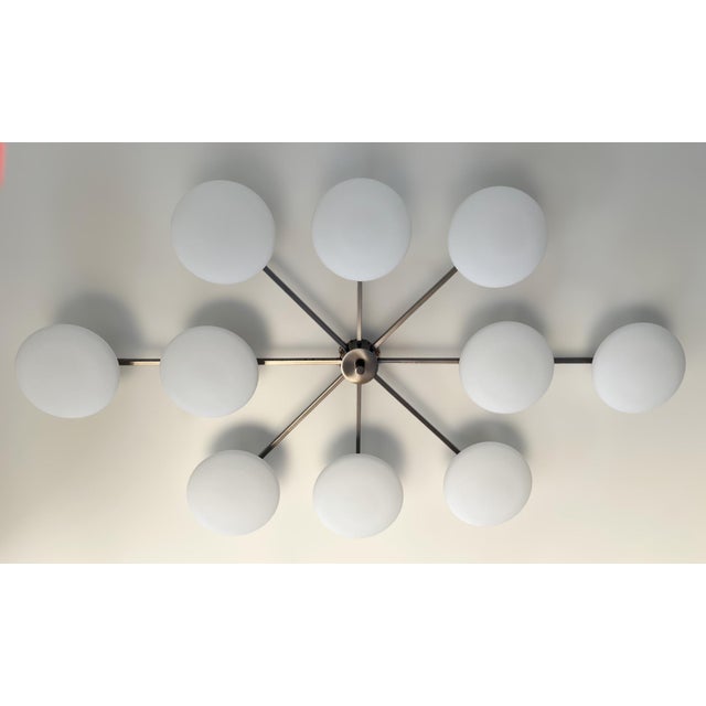 Italian midcentury flush mount with ten matte white Murano glass shades mounted on solid brass frame in satin black nickel...