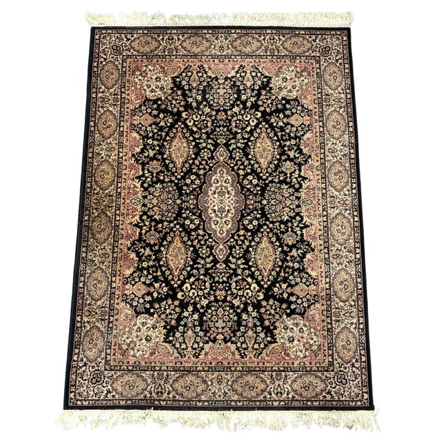 A beautifully hand-knotted Oriental area rug featuring a classic floral medallion design set against a rich black field...