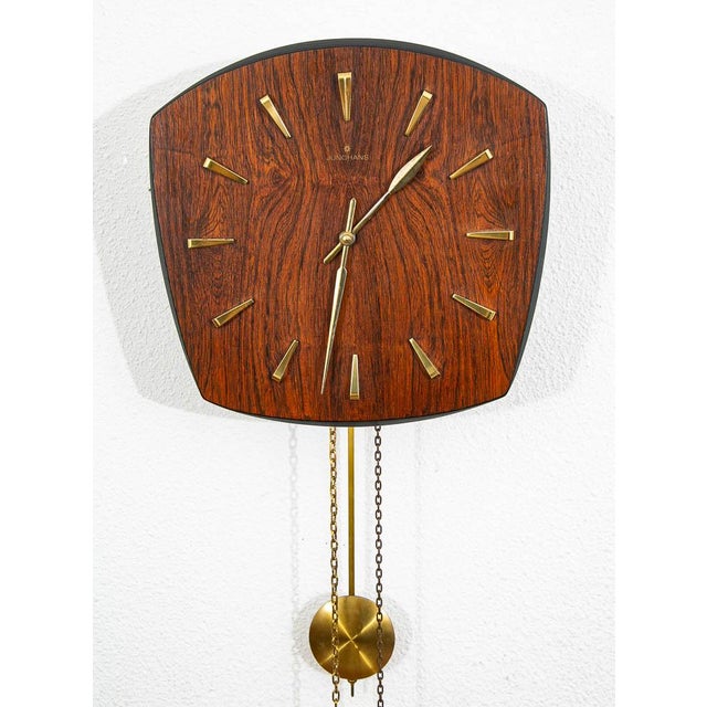 Unique rosewood wall clock by Junghans. Comes with weights as well as original pendulum and offers a chime. May need to be...