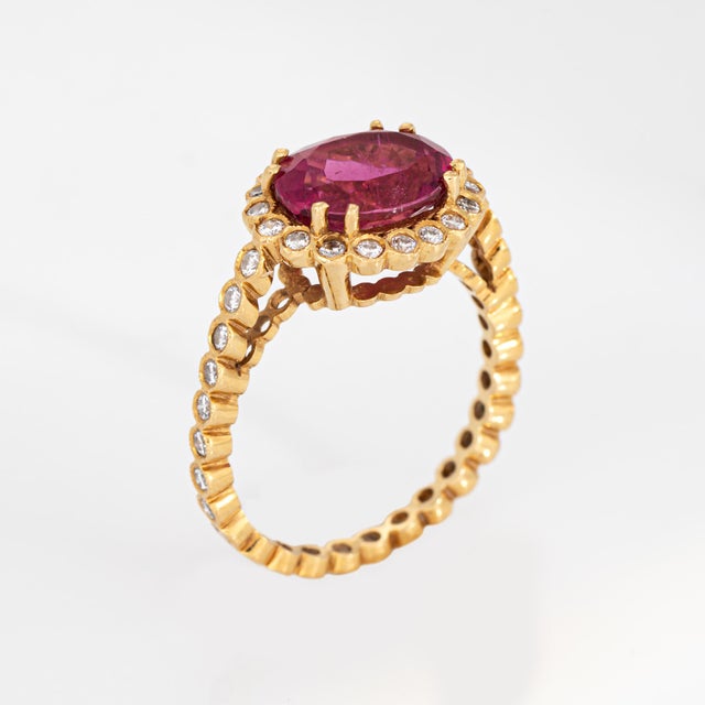 Stylish contemporary pink tourmaline cocktail ring crafted in 18k yellow gold. Faceted oval cut pink tourmaline 10mm x...