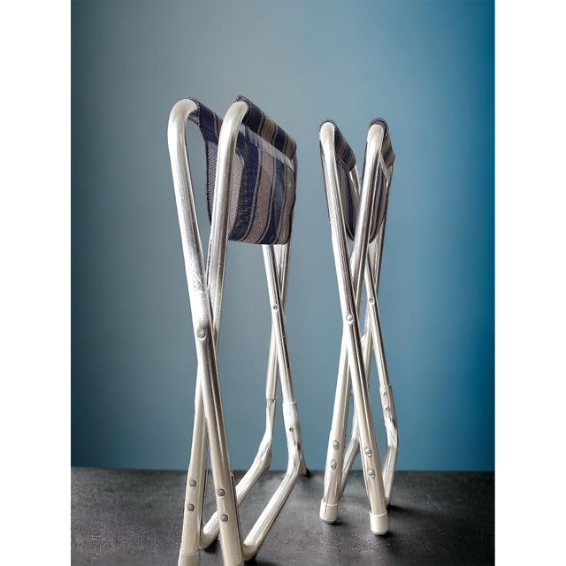 Vintage danish folding stools produced during the 1970s. executed with tubular steel frames and striped fabric seats,...