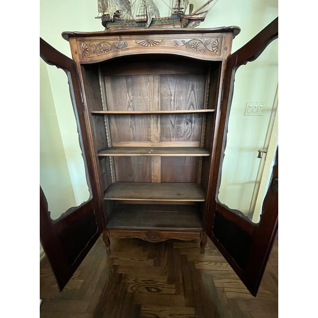 Beautiful wood sheen with French carvings and glass doors for easy display of books, china or other collectibles.
