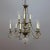 A vintage French chandelier offers tiered brass frame with scroll form arms terminating in nine candle lights with strung...