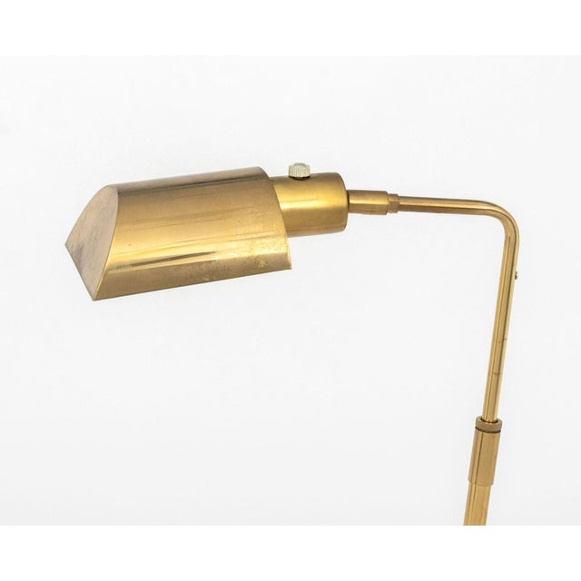 Modern Brass Adjustable Floor Lamp, with articulated light on rectangular base. 45.75" H x 17.5" W x 6.25" D. Provenance:...