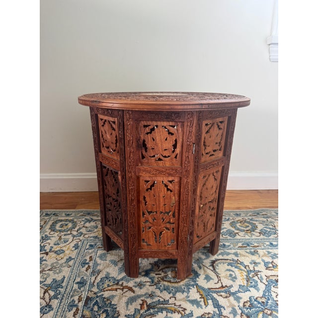 Listing is for a vintage Anglo Indian wooden table with shell inlaid decoration centered with carved floral surround....