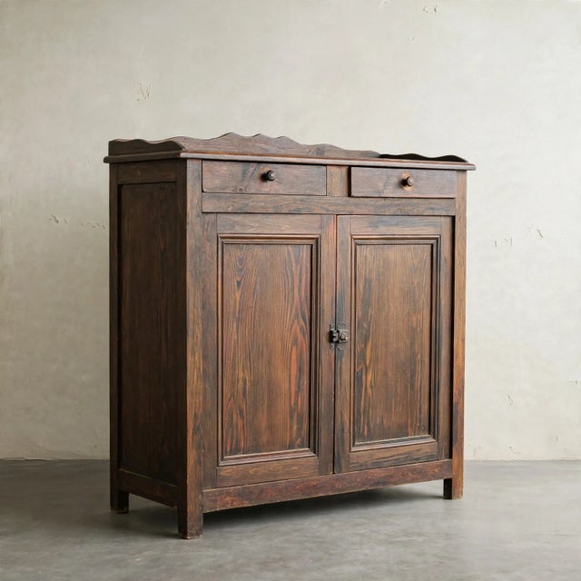 A beautifully aged antique pine cabinet with rich, warm patina and loads of old-world character. The cabinet features two...