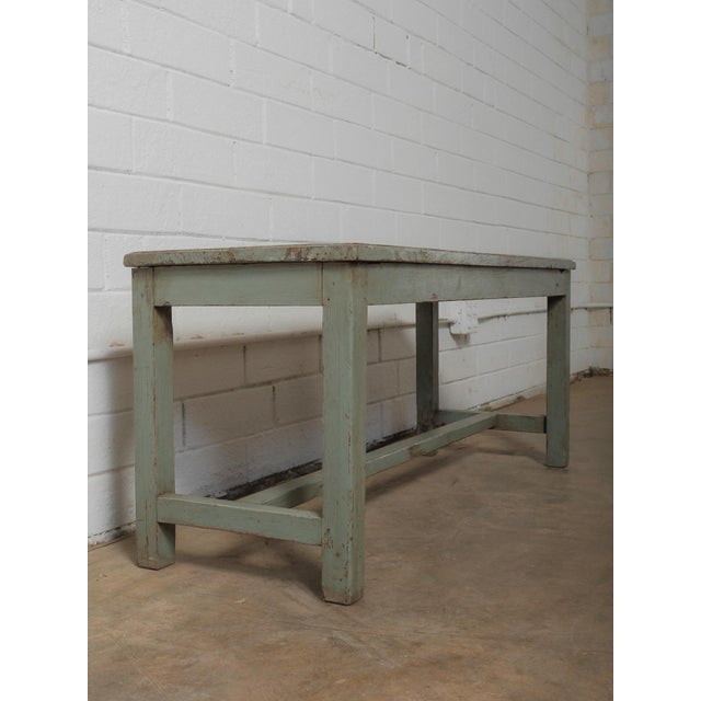 A study in quiet character, this wooden bench reveals layers of time through its softly distressed green finish and gently...