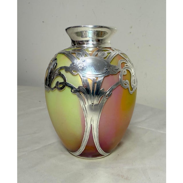 The Antique Hand Blown Loetz Candia Silberiris Sterling Silver Overlay Glass Vase is a stunning piece of art glass...