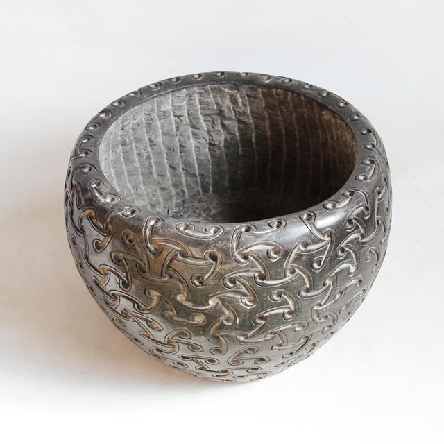 Hand carved solid black marble bowl with repeating woven geometric design. Opening at top measures 19" diameter. No...