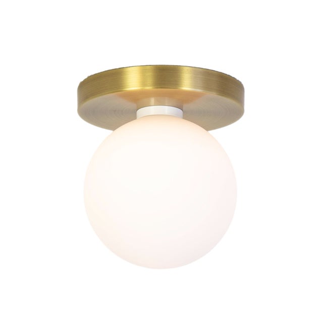 Minimal from top to bottom. This black flush mount pairs a metal base with a soft glass globe. Cool, calm, and quietly...
