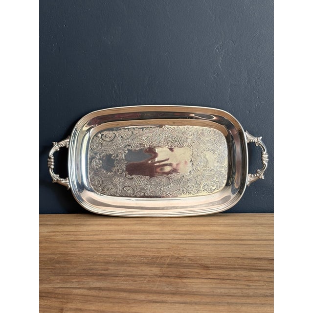 Small oblong serving tray, silverplate on copper, with cast acanthus-scroll handles. Machine-chased rococo scrollwork on a...