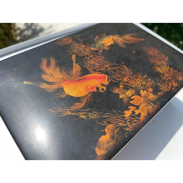 This box is in a black and Orange lacque. It has been made in Vietnam circa 1970. The decorative pattern is with fishes...