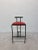 Postmodern Tokyo counter stool made of a satin black steel frame, curved black polyurethane backrest and a red naugahyde...
