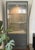 A postmodern display cabinet with interior light in rare gray lacquer and glass, late 20th century. With gold-toned...