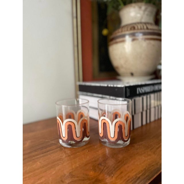 A fabulous pair of 1970s glassware, the show a wave that wraps around the entire glass and three colors, a chocolate...