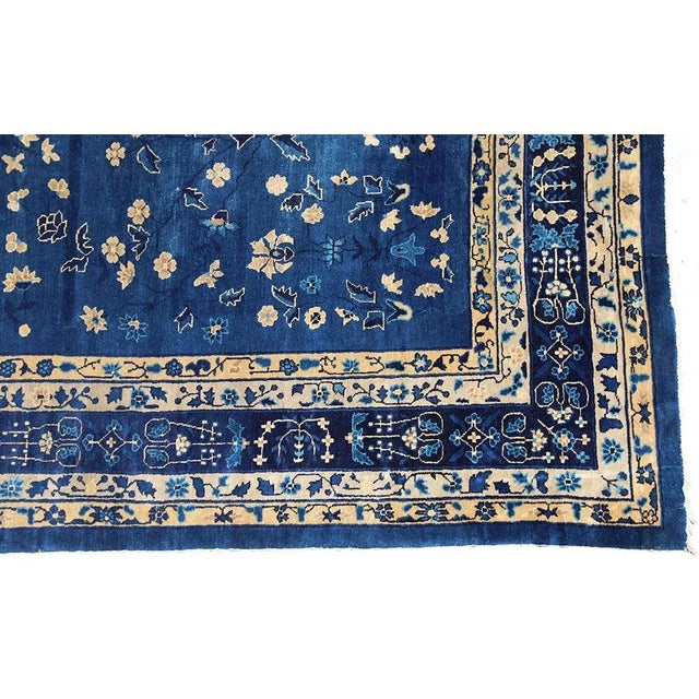 This antique Chinese Peking hand knotted woolen rug dates back to the late 1800s and features a captivating indigo...