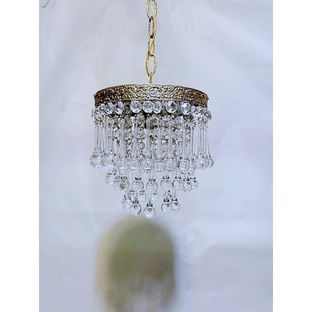 Italian layered chandelier with decorative brass rim, octagon beads and hand blown teardrops. It has 3 layers of crystals...