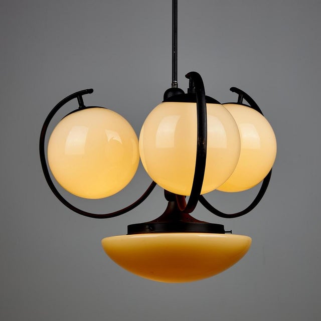 An Art Deco-style chandelier with a rosette-patterned ceiling rose and four glass shades. with some surface scratches,...