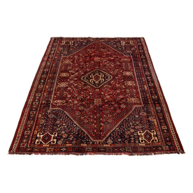Elevate your space with this exquisite allover-designed Persian Shiraz wool rug, crafted in a rich and timeless red hue....