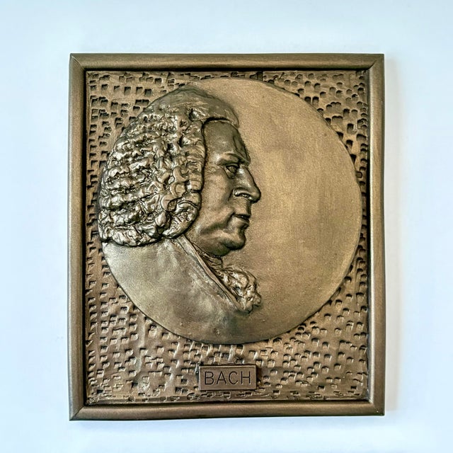 A vintage pair of decorative metal wall plaques depicting renowned composers Johann Sebastian Bach and Frédéric Chopin in...
