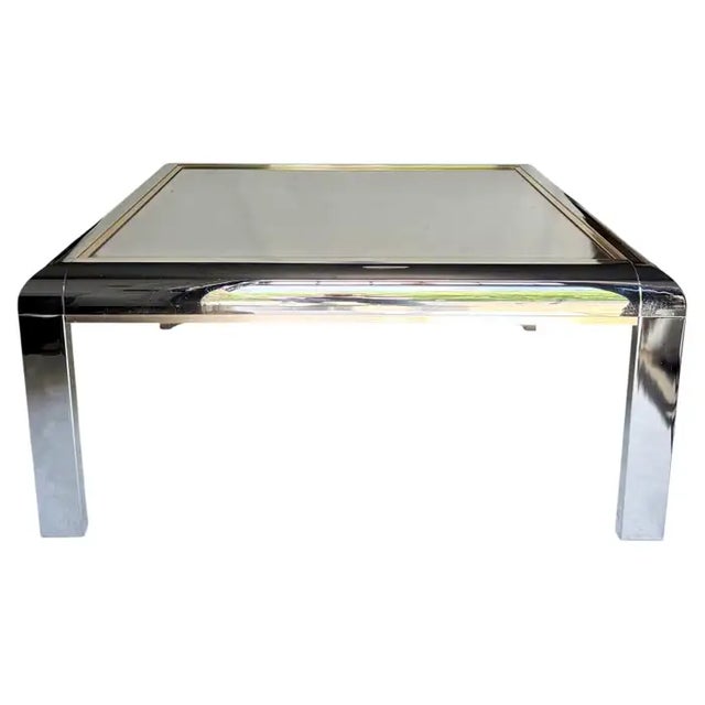 Sleek Mid-Century Modern square glass coffee table featuring a tinted black / dark gray tone reflective mirrored top. The...