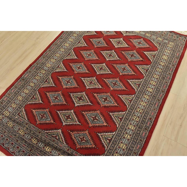 A tribal Bokhara Jaldar rug hand-knotted with fine wool on a cotton foundation. This rug features rows of repeating...
