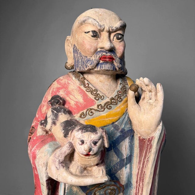 This impressive pair of hand-carved, polychrome figures is made from wood and stands on pronounced lotus bases....