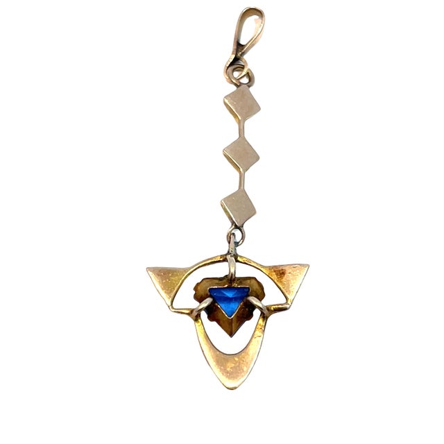 Elegant 14k yellow gold dangling pendant featuring a beautifully cut blue sapphire accented with delicate seed pearls....
