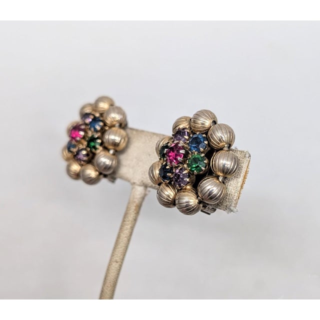 1960s goldtone ribbed balls around the edges with a prong set round faux-ruby in the center surrounded by prong set round...