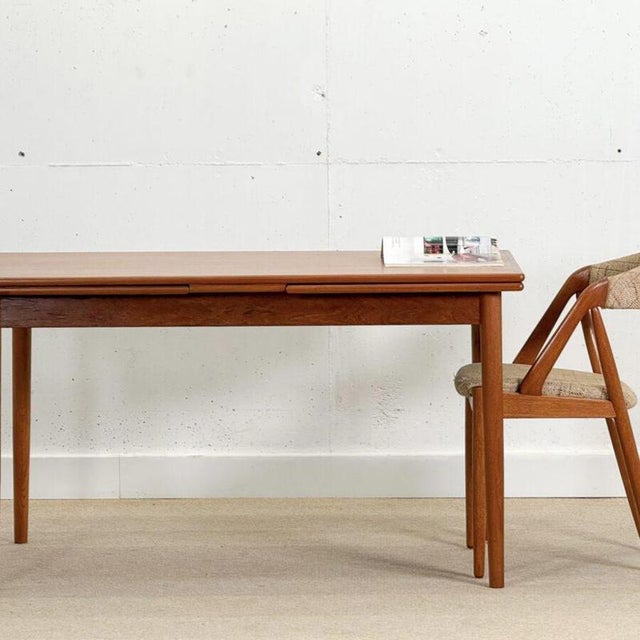 Beautiful mid-century extending dining table made in Denmark from teak. The table features two extensions, one on each...