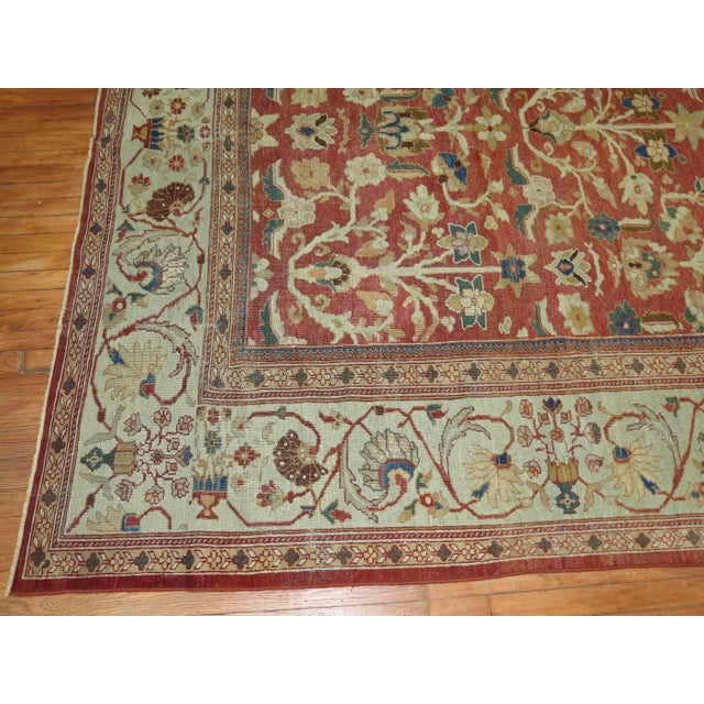 An incredible antique Persian Sultanabad with a compelling all-over design, gray-blue border set on a burnt red field....