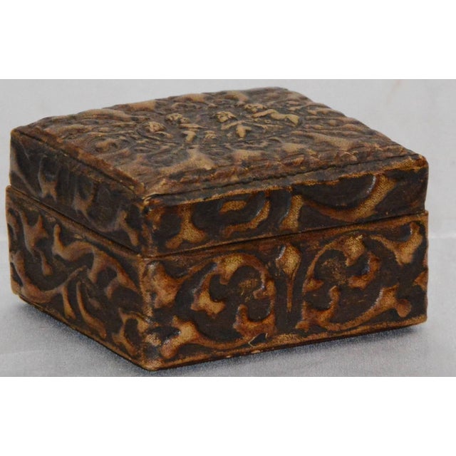 Softly worn embossed leather graces this lovely fabric lined box. Playful cherubs dance on the top and the detailed swirls...