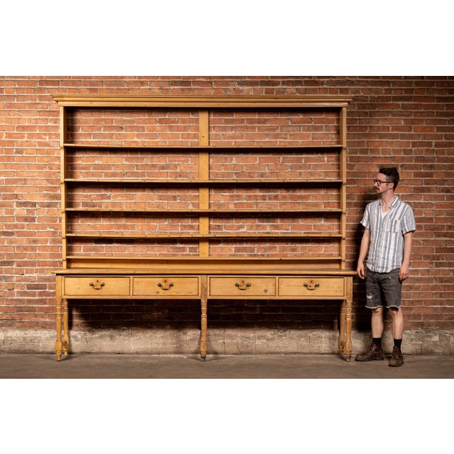 Large-scale pine farmhouse dresser or hutch constructed in two parts, featuring an expansive open plate rack above a long...