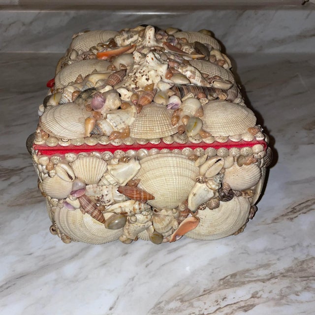 Vintage seashell encrusted box that is lined in red velvet. Decorated with an assortment of shells arranged in a low-...