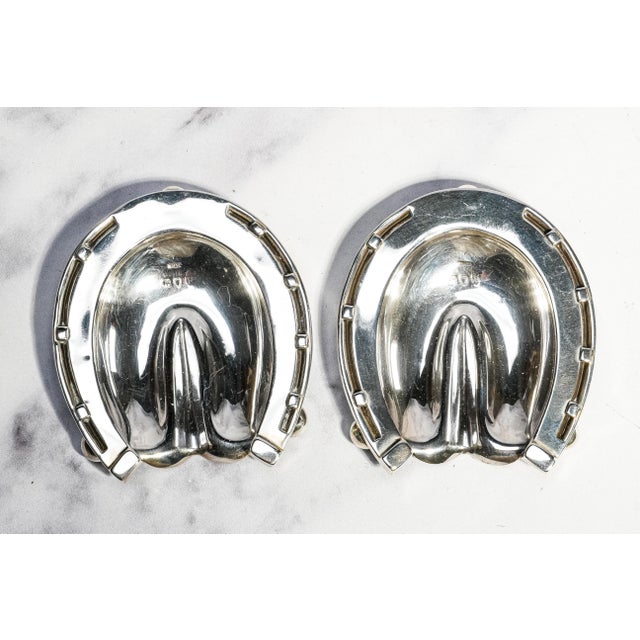 A rare and highly collectible pair of antique sterling silver horseshoe dishes by the renowned London silversmith Sampson...