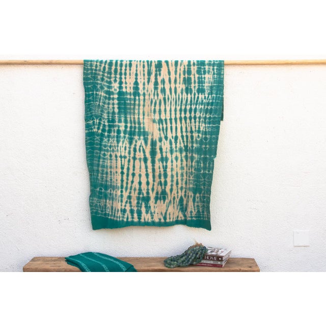 A rare regional variation of West African indigo, featuring saturated teal-green hues and hand-stitched details. This...