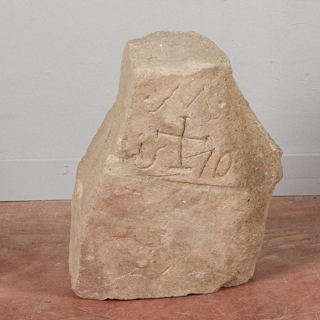 This is an irregular fragment of light beige limestone or sandstone, with a rough, porous surface. Its shape is massive...