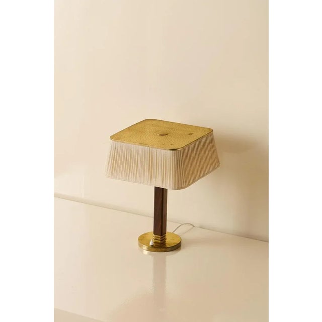 Paavo Tynell table lamp in brass with perforated shade. Manufactured by Taito Oy, Finland, circa 1940s. This piece is...