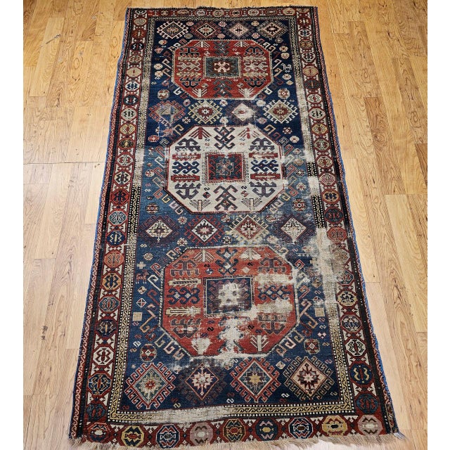 This antique Caucasian Kazak rug from the late 19th century features a bold and balanced triple medallion design set...