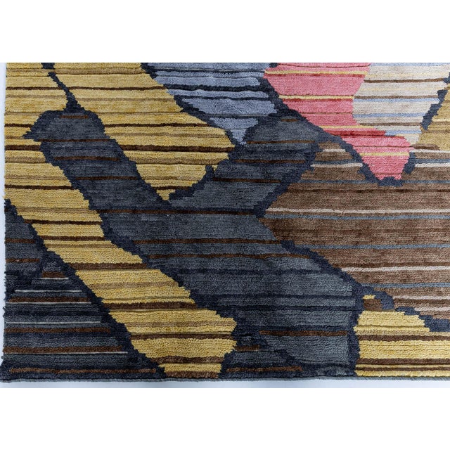 This striking modern Sauron rug features a bold, abstract composition defined by layered geometric forms and dynamic...